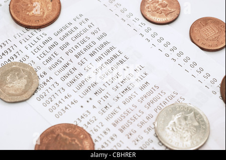 Supermercato shopping bill fino alla ricevuta di acquisto più risparmi con monete Foto Stock