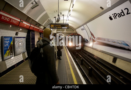 La metropolitana di londra treno in arrivo nella stazione di Bond street con i passeggeri in attesa England Regno Unito Regno Unito Foto Stock