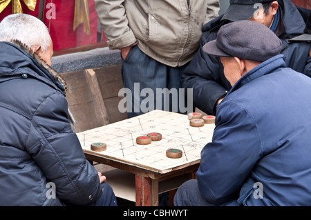 Vecchio cinese gli uomini che giocano a scacchi cinesi (xiangqi) Foto Stock