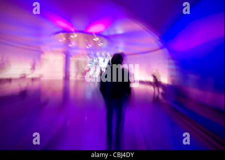 Silhouette misterioso uomo a camminare nel tunnel colorati Foto Stock