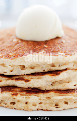 Il siero di latte fresco frittelle con cucchiaio di burro sulla piastra bianca Foto Stock