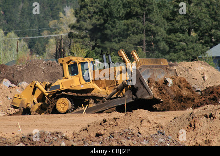 Grande giallo bulldozer sposta il terreno in corrispondenza di un sito in costruzione Foto Stock