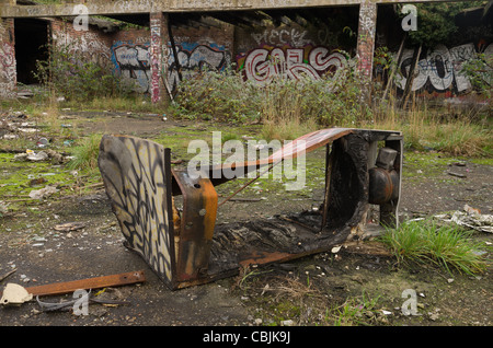 Resti di bruciato frigo ora la formazione di ruggine nel vandalizzato la scuola primaria che è stata chiusa, questo è stato il parco giochi Foto Stock