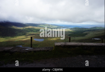 Paesaggio panoramico vista da Conor Pass di Dingle Bay di Kerry, Irlanda con drammatica nuvole ombra tra le colline. Foto Stock
