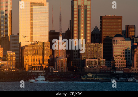 Un bellissimo tramonto di Seattle si riflette nelle facciate dei palazzi di vetro lungo il centro cittadino di lungomare della Baia di Elliott. Foto Stock