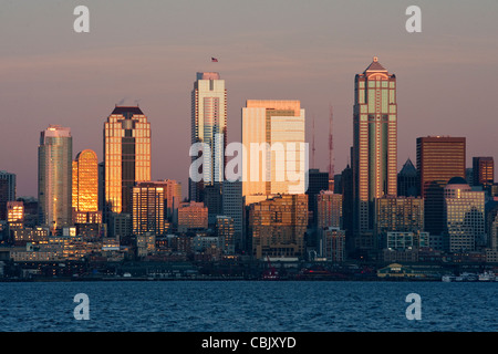 Un bellissimo tramonto di Seattle si riflette nelle facciate dei palazzi di vetro lungo il centro cittadino di lungomare della Baia di Elliott. Foto Stock