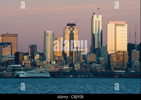 Un bellissimo tramonto di Seattle si riflette nelle facciate dei palazzi di vetro lungo il centro cittadino di lungomare della Baia di Elliott. Foto Stock