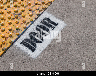 Indicazioni per la linea ferroviaria leggera posizione porta dipinta su asfalto a Denver in Colorado. Foto Stock