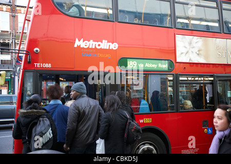 Persone imbarco red double deck bus nella mattinata Londra Inghilterra Regno Unito Regno Unito Foto Stock