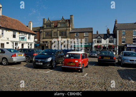 Parcheggio auto parcheggiato nel centro della città Market Place Thirsk North Yorkshire Inghilterra Regno Unito GB Gran Bretagna Foto Stock