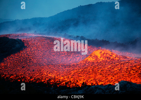 Novembre 2006 - Boulder rotolamento nel flusso di lava al crepuscolo durante l eruzione del Monte Etna, Sicilia, Italia. Foto Stock
