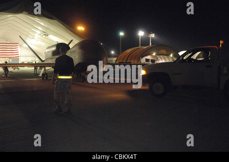 I membri del 380esimo Squadron di manutenzione di velivoli Expeditionary hanno riportato un sistema aereo senza equipaggio RQ-4 Global Hawk in un gruccia dopo una missione del 11 marzo nel sud-ovest asiatico. La 380a Ala Air Expeditionary è stata parte integrante del Global Hawk che ha recentemente raggiunto le sue tappe fondamentali di 10 anni e 20,000 ore di volo. Foto Stock