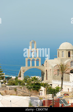 Chiesa Greco Ortodossa con porta ad arco che si affaccia sul mare Egeo nel villaggio di Karterodos, Fira, Grecia Foto Stock