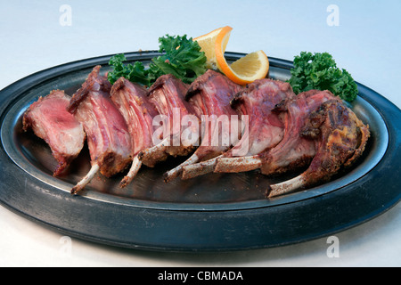 Costolette di agnello sul piatto di portata con guarnire con prezzemolo e orange USA Foto Stock