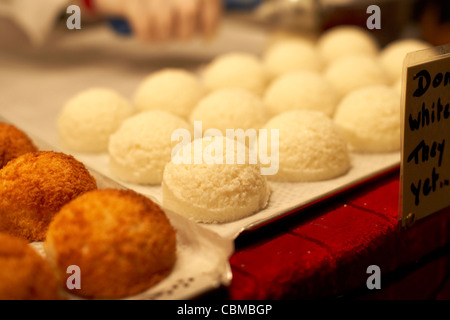 Amaretti al cocco pronto per essere cotto su un vassoio su una fase di stallo a Belfast Irlanda del Nord Regno Unito Regno Unito Foto Stock