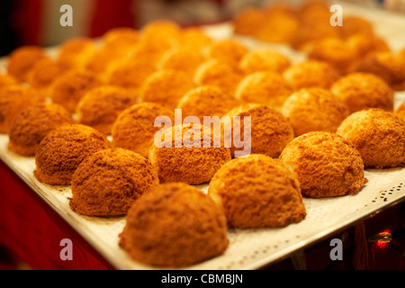 Vassoio del pane appena sfornato amaretti di cocco su una fase di stallo a Belfast Irlanda del Nord Regno Unito Regno Unito Foto Stock