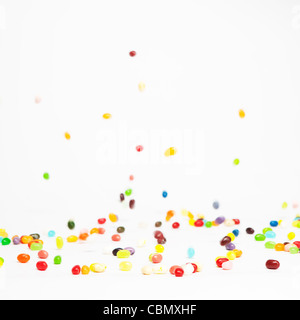 Colorate caramelle gommose essendo lasciata cadere da una altezza su uno sfondo bianco Foto Stock