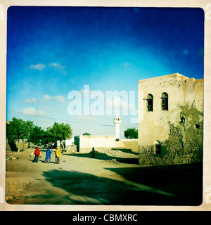 Tre donne in una strada di Berbera minareto della moschea in background Berbera Somaliland Foto Stock