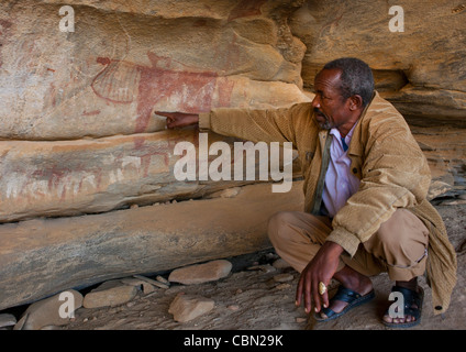 Lasa Geel Arte Rupestre Grotte, Squatting guida per spiegare il significato dei dipinti Foto Stock