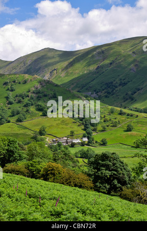 Troutbeck Park Farm, Cumbria. La scesa noto come la lingua è dietro la fattoria oscurato dalle vette più elevate del malato campana dietro Foto Stock