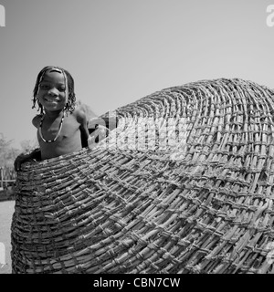 Mudimba Ragazza in un cestello gigante, Angola Foto Stock