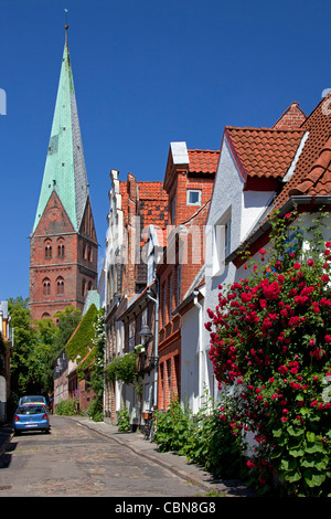 Street con facciata giardini e chiesa di Saint Aegidien a Lubecca, Germania Foto Stock