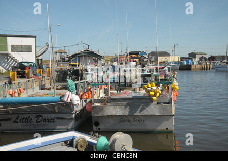 Un pescatore si erge sul ponte di un commerciale barca da pesca come si entra in porto nel nord del Lago in porto P.E.I. Foto Stock