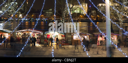 Vista il tradizionale Mercatino di Natale lungo la sponda sud della regina di Londra a piedi di notte Foto Stock