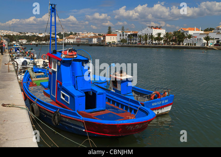 Barche da pesca legato fino al molo di Tavira, Algarve, Portogallo. Brillante vernice blu su due delle imbarcazioni. Foto Stock