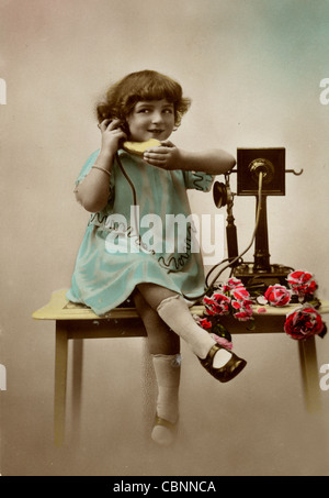 Bambina parlando al telefono antico Foto Stock