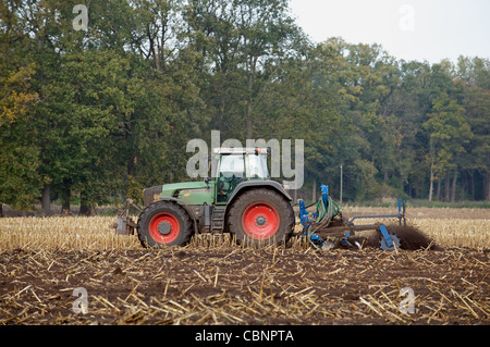 Agricoltore la guida un tedesco costruito trattori Fendt per coltivare un campo, Strohen, Bassa Sassonia, Germania. Foto Stock