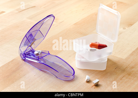Pillboxes e pillole reciso dalla pillola coltello su tavola in legno Foto Stock