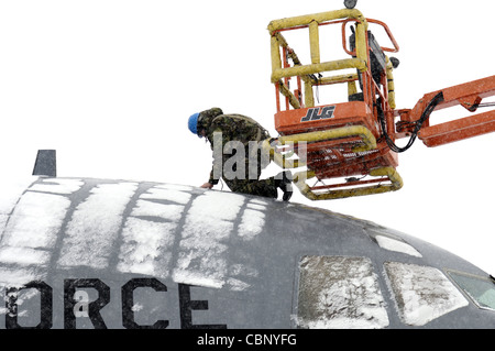 Airman Russell Baker, un journeyman di sistemi di alimentazione, lavora sul recipiente di rifornimento di aria di un C-17 Globemaster III 7 marzo durante una tempesta di neve che ha colpito la base dell'aeronautica McGuire, N.J. Airman Baker è assegnato il 305esimo Squadron di manutenzione. Foto Stock