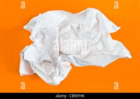 Palla di accartocciata della carta da ufficio su sfondo arancione Foto Stock