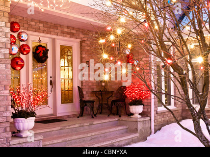 Home ingresso decorato per il Natale compresi luci, corona, bistro sedie e tavolo. Foto Stock