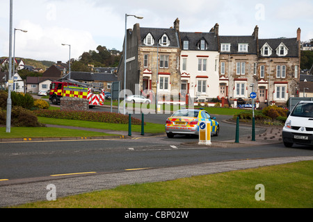 Motore Fire & auto della polizia accelerando attraverso strade di Oban, Scozia, sul modo di incendio o di incendio doloso su un grido di emergenza Foto Stock