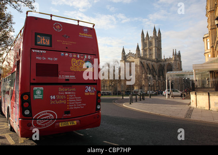 Red bus turistico vicino a Abbazia di Bath, bagno, Inghilterra Foto Stock