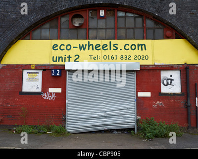 Chiuso officina o garage sotto arch a Manchester REGNO UNITO Foto Stock