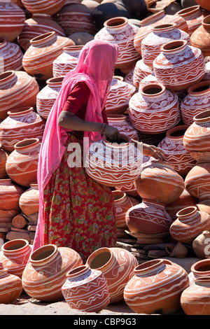 Donna indiana la vendita di argilla vasi d'acqua in vendita nella città vecchia Udaipur, Rajasthan, stato dell India occidentale, Foto Stock