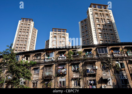 Vecchio tradizionale tenement alloggiamento nell'ombra del nuovo alto e moderno appartamento a blocchi Mahalaxmi in Mumbai, India Foto Stock