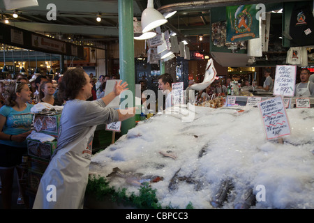 Gettando il salmone fresco presso il Pike Place Market pubblica, Seattle, Washington, Stati Uniti d'America Foto Stock