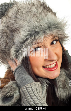 Felice donna sorridente nel cappello di pelliccia isolati su sfondo bianco Foto Stock