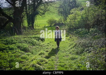 Donna che cammina lungo una traccia sulla South Downs, West Sussex, Regno Unito Foto Stock