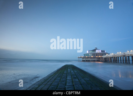 Blankenberge pier in Fiandra occidentale, Belgio, nella luce della sera, con jetty in primo piano. Foto Stock