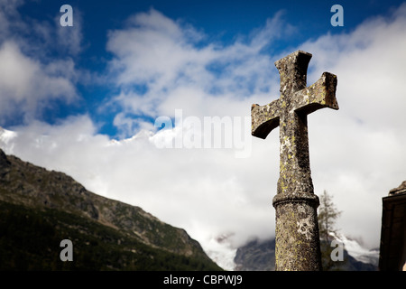 Croce di pietra appartenenti alla chiesa del villaggio a Macugnaga sotto il massiccio del Monte Rossa, Italia settentrionale. Foto Stock