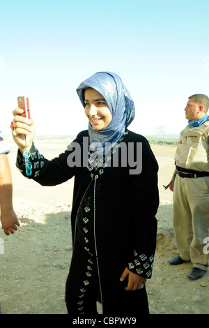 Ragazza con telefono con fotocamera visitare i resti di un antico tempio presso il luogo di nascita di Abramo, Borsippa, Iraq Foto Stock