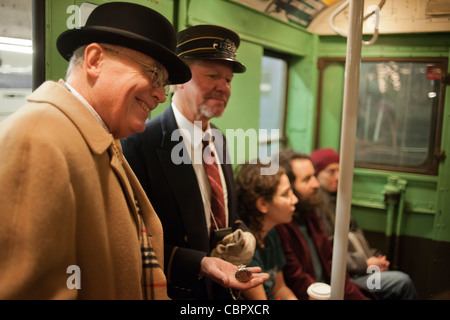 I Newyorkesi, i turisti e gli appassionati della metropolitana, alcuni nel periodo abito, a un MTA vintage Nostalgia treno stagione di Natale ride Foto Stock