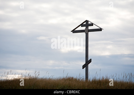 Legno di grande croce cristiana sul cielo nuvoloso scuro dello sfondo Foto Stock