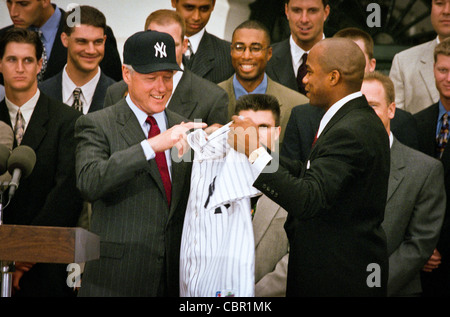 Il presidente Bill Clinton, indossando una New York Yankees cappello da baseball accetta un NY Yankees jersey dal lanciatore Orlando Hernandez come il 1998 World Series vincendo Yankees ha visitato la Casa Bianca Giugno 10, 1999 a Washington, DC. Foto Stock