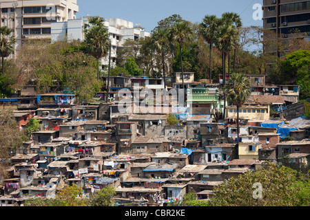 Baraccopoli alloggiamento e gli abitanti degli slum accanto a blocchi di appartamenti in Bandra area di Mumbai, India da Bandra worli sealink Road Foto Stock